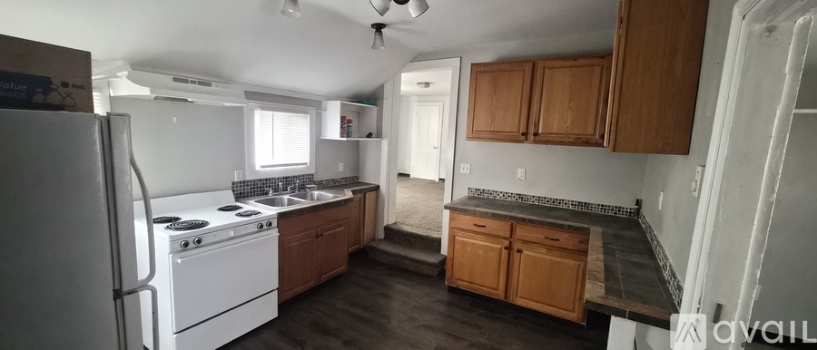 A kitchen with white appliances and wooden cabinets.
