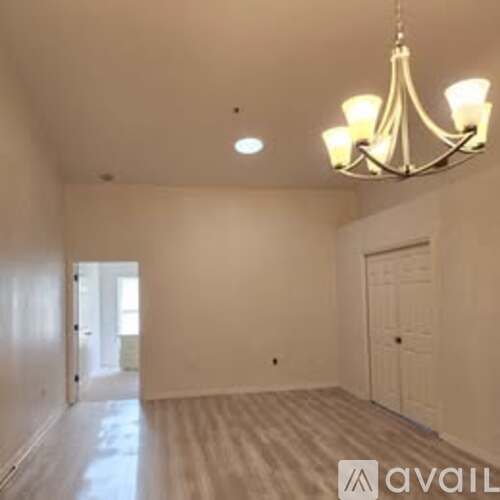 A room with a chandelier and a door is available for rent.