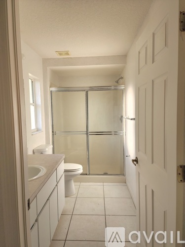 A bathroom with a toilet, sink, and shower.
