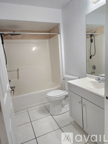 A bathroom with a toilet, sink, and shower.
