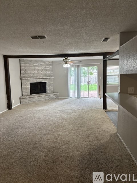 A living room with a fireplace and a carpeted floor.
