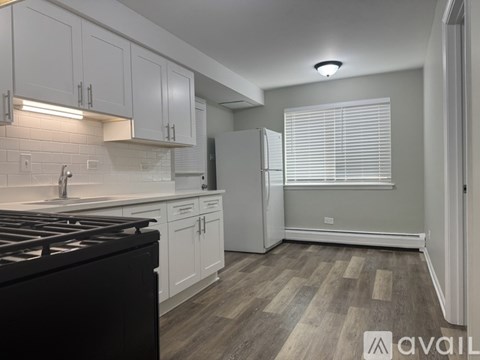 A kitchen with white cabinets and a black stove top.