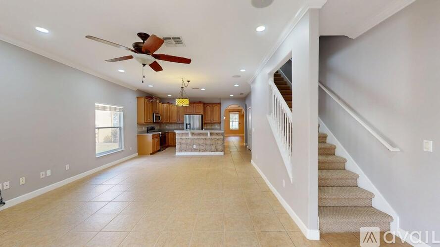 A spacious living room with a staircase leading to the upper floor.