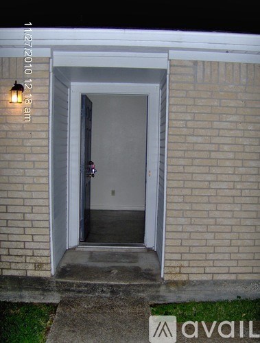 A doorway in a brick wall with a light on.