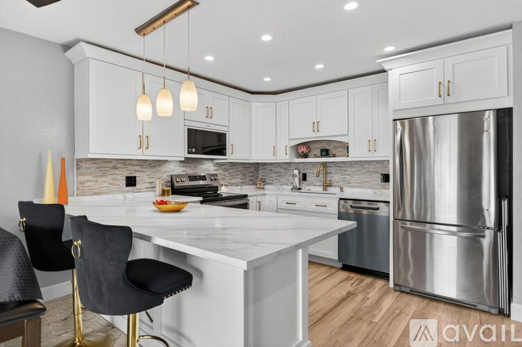 A modern kitchen with a white island and stainless steel appliances.