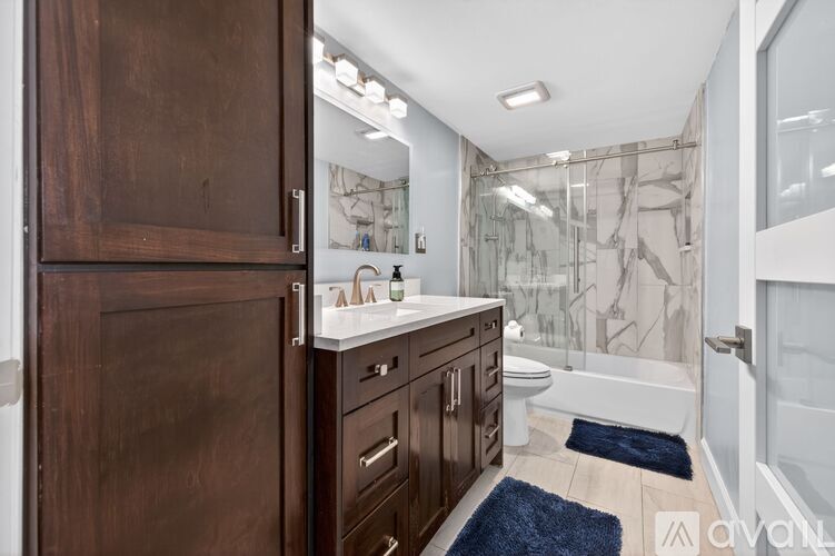 A bathroom with a brown cabinet and a white sink.