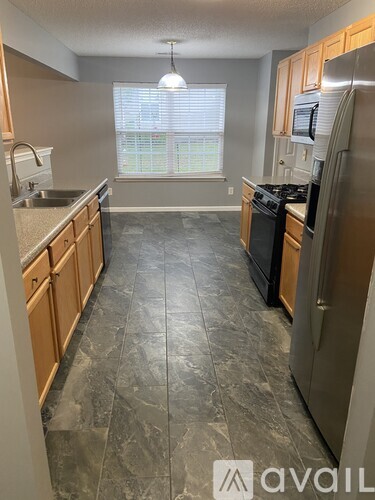 A kitchen with granite countertops and wooden cabinets.