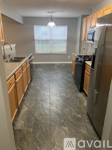 A kitchen with granite countertops and wooden cabinets.