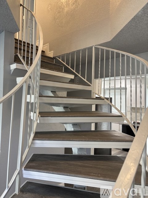 A spiral staircase with wooden steps and white railings.