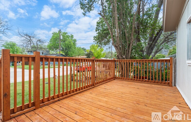 A wooden deck with a gate leading to a grassy area.
