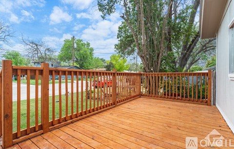 A wooden deck with a gate leading to a grassy area.