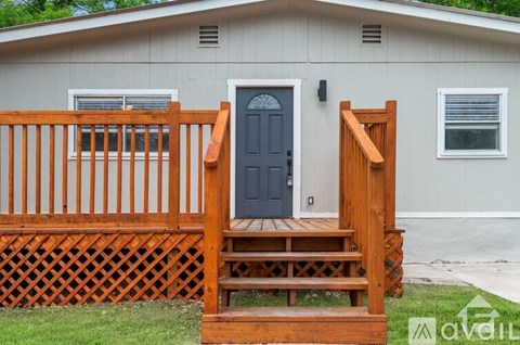 A house with a wooden deck and a blue door.