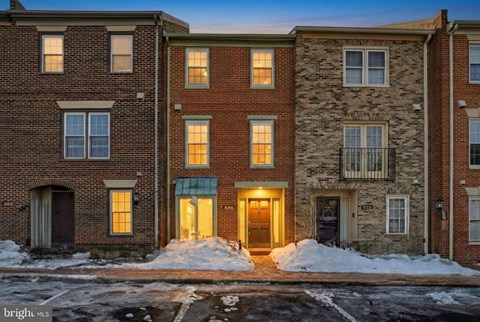 A row of townhouses with snow on the ground.