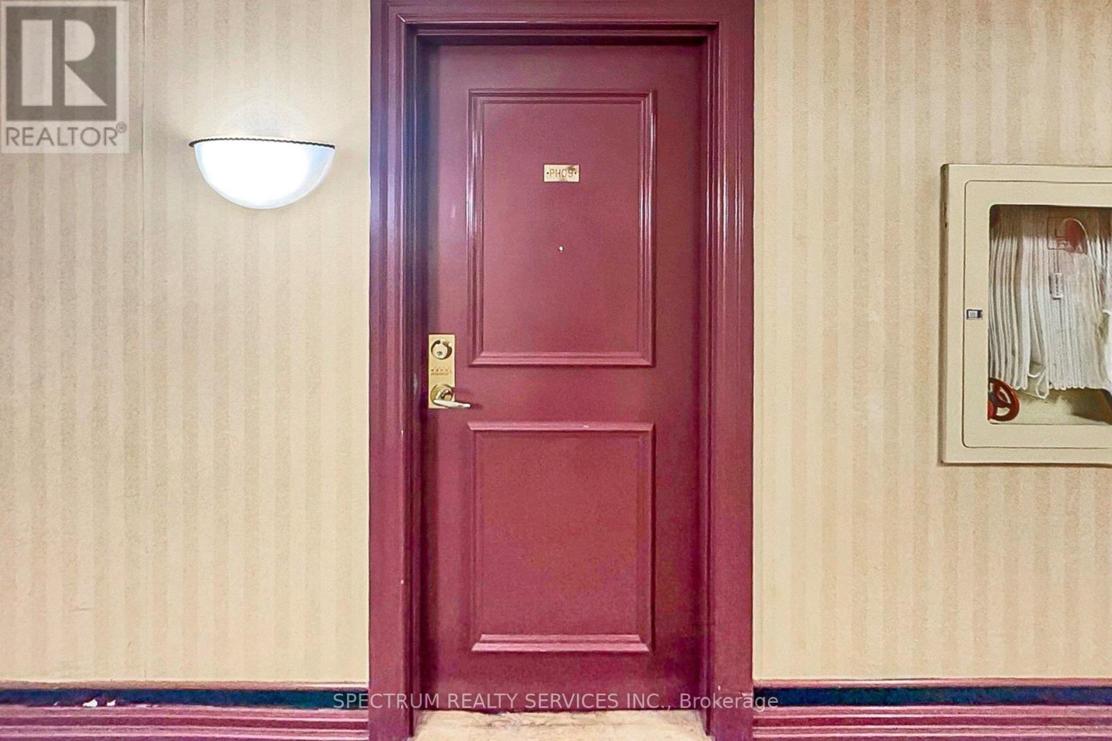 A red door with a gold handle and a light above it.