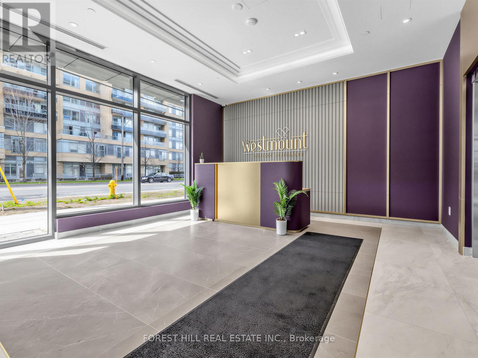 A reception area with a black carpet and a gold reception desk.