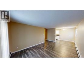 A spacious room with wooden flooring and a white ceiling.