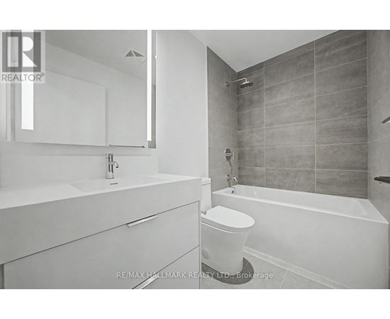 A white bathroom with a tub, sink, and toilet.