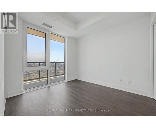 A spacious room with a view of the city through large windows.