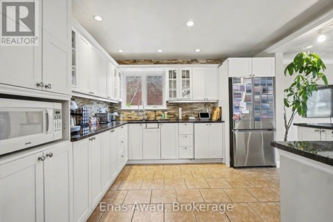 A kitchen with white cabinets and a tiled floor.