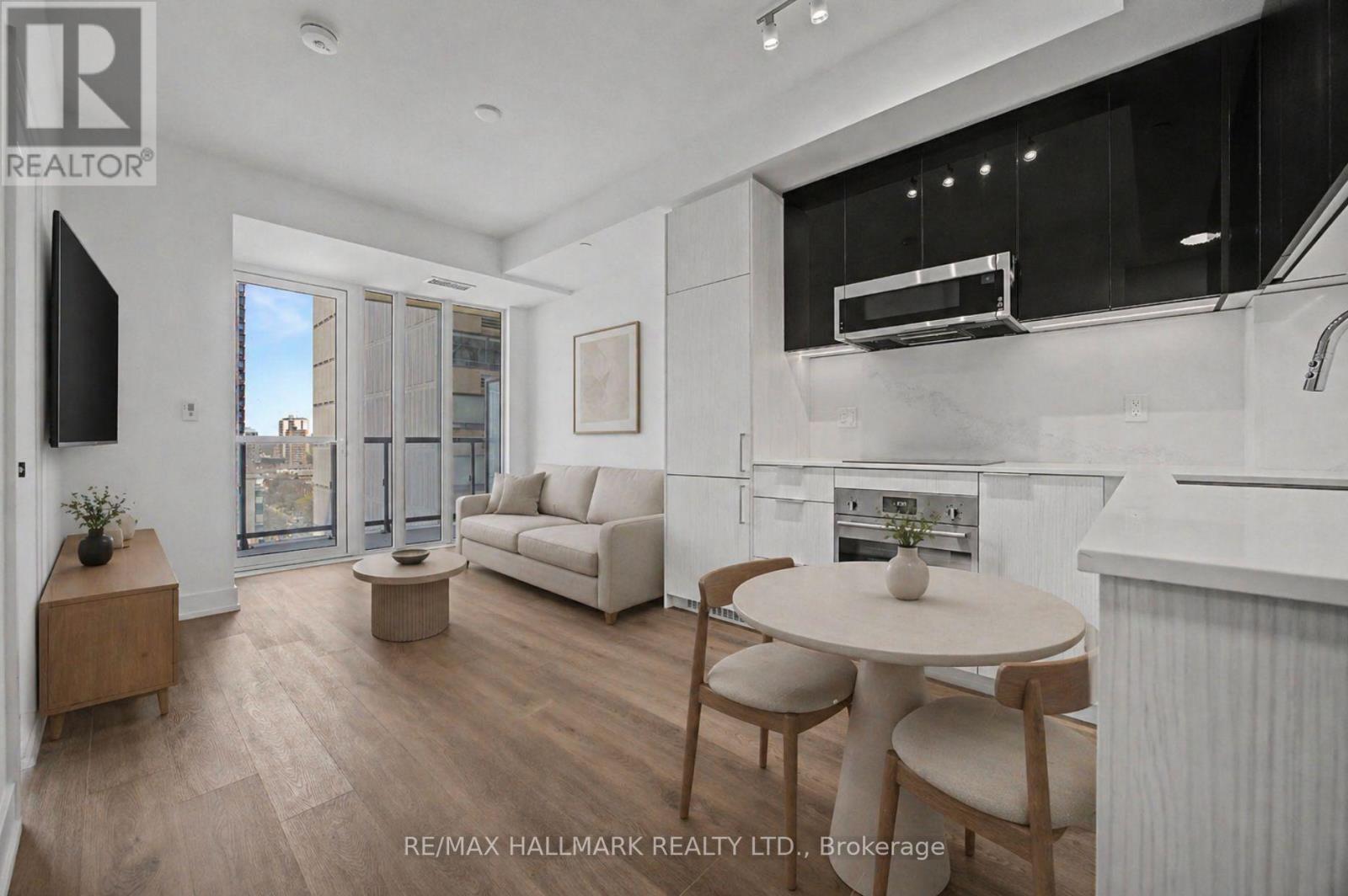 A modern kitchen and living room with white appliances and furniture.