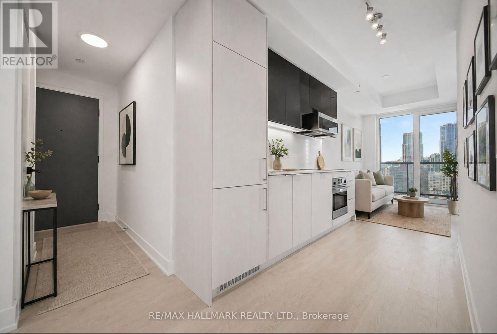 A well-lit, modern kitchen with white cabinets and a large window.