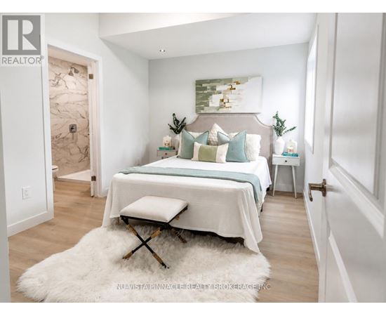 A bedroom with a bed, a bench, and a painting on the wall.