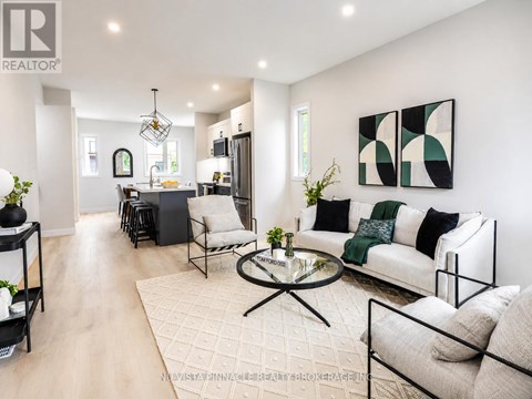 A modern living room with a glass coffee table and a white sofa.