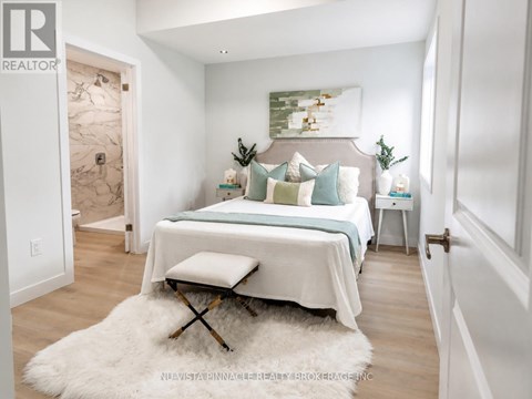 A bedroom with a bed, a bench, and a painting on the wall.