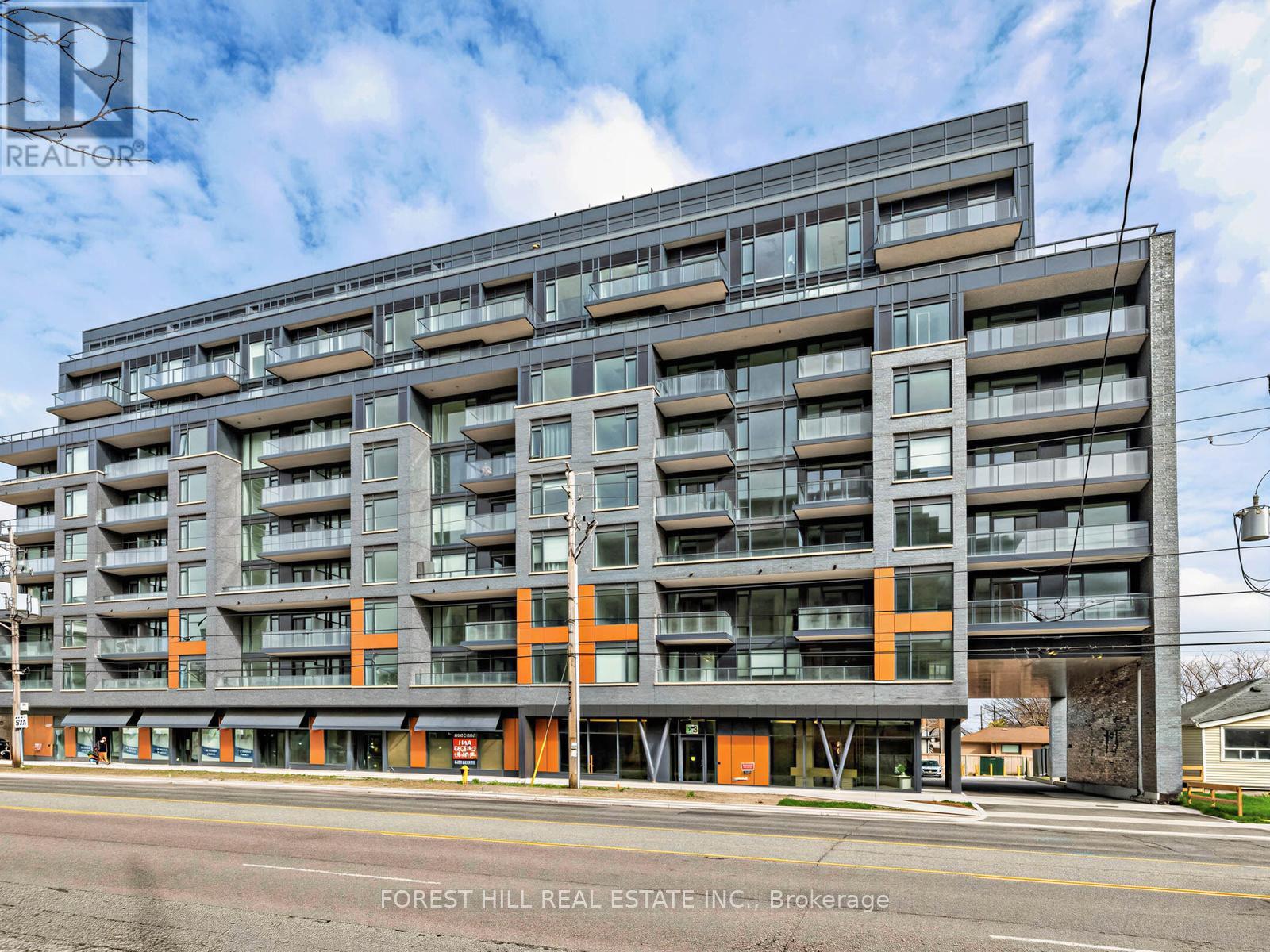 A large multi-story building with balconies and orange accents is for sale.