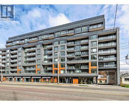 A large multi-story building with balconies and orange accents is for sale.