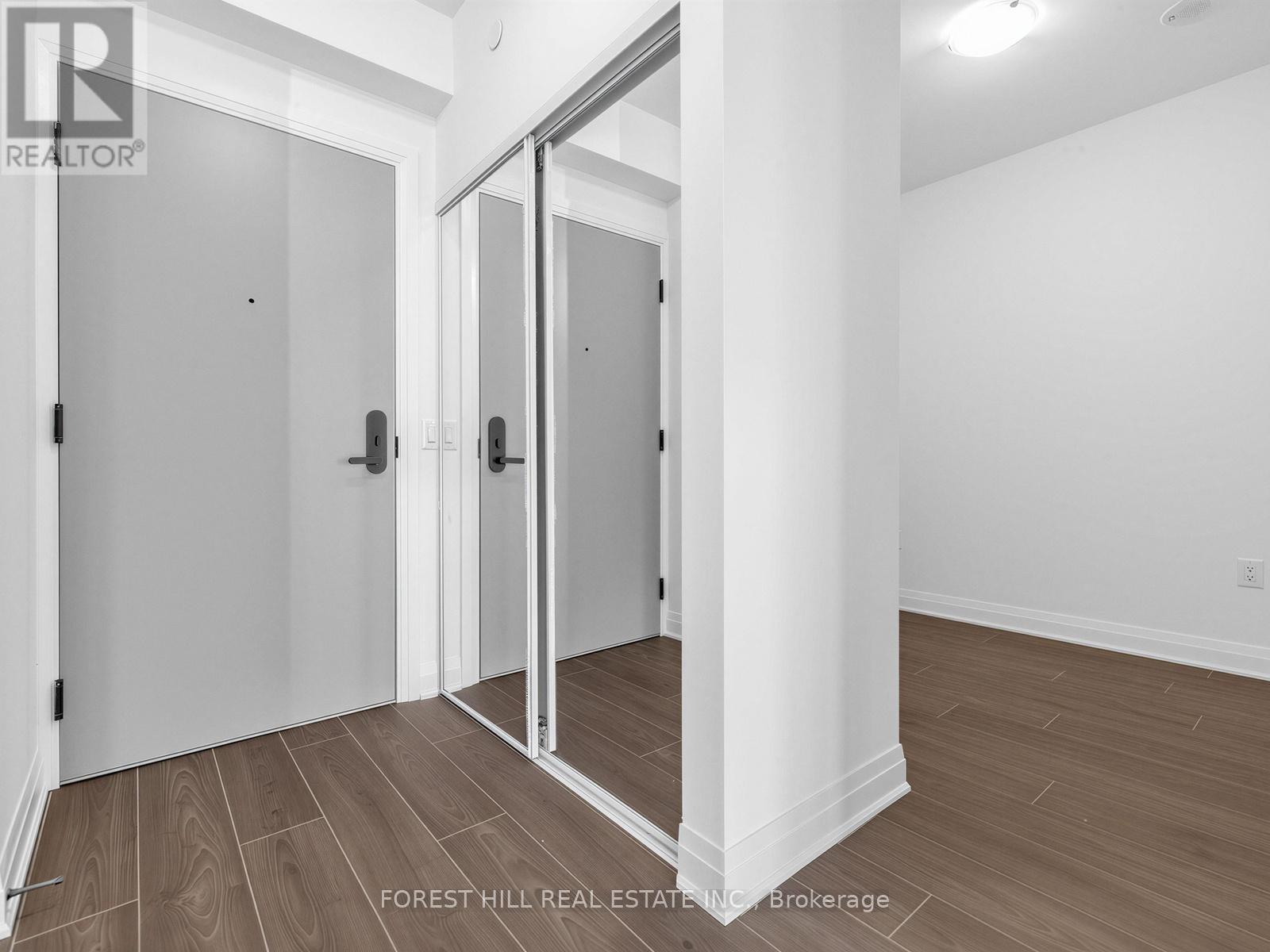 A room with a white wall and a wooden floor with a glass door.