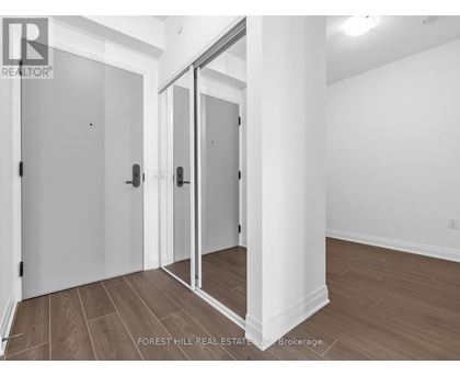 A room with a white wall and a wooden floor with a glass door.