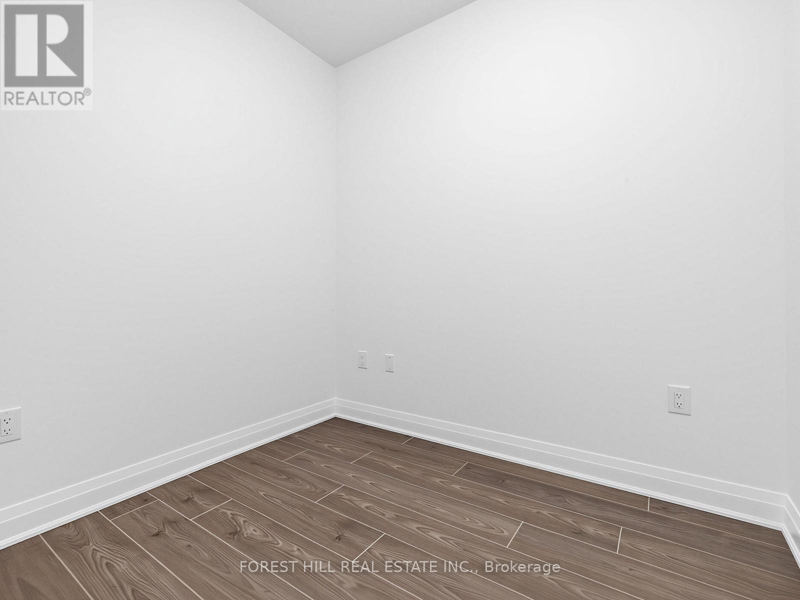 A room with wooden flooring and white walls.