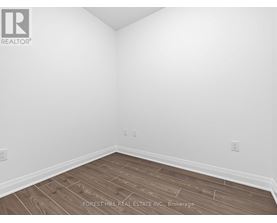 A room with wooden flooring and white walls.