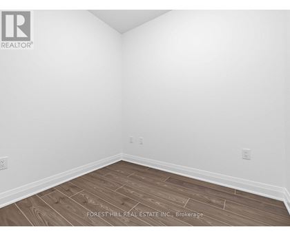 A room with wooden flooring and white walls.