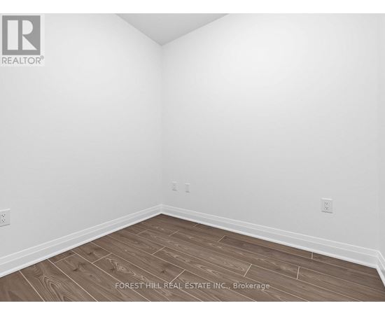 A room with wooden flooring and white walls.