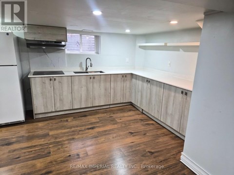 A kitchen with wooden floors and cabinets.