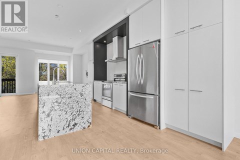 A kitchen with a marble island and stainless steel appliances.