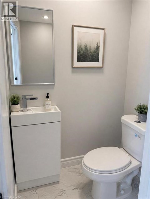 A white toilet sits next to a white sink in a bathroom.