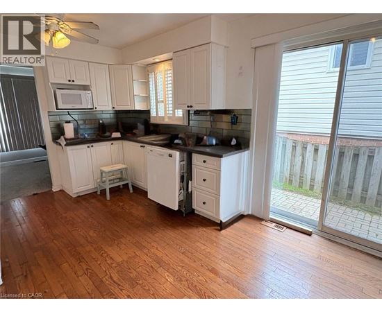 A kitchen with white cabinets and a black countertop.