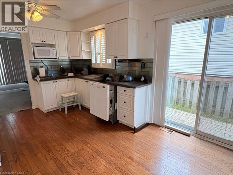 A kitchen with white cabinets and a black countertop.