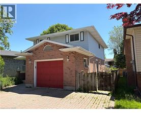 A house with a red garage door is surrounded by a wooden fence.