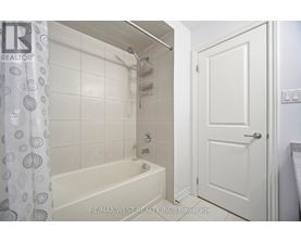 A white bathroom with a bathtub and a door.