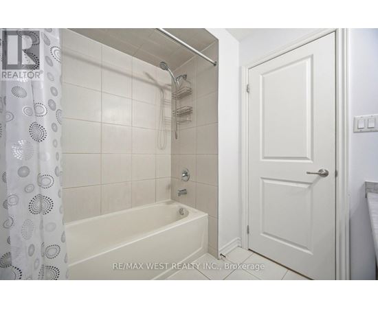 A white bathroom with a bathtub and a door.