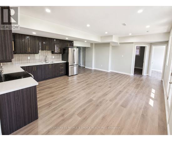 A spacious kitchen with dark wood cabinets and a white countertop.