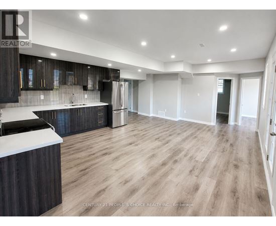 A spacious kitchen with dark wood cabinets and a white countertop.