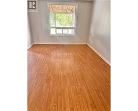 A room with wooden flooring and a window.
