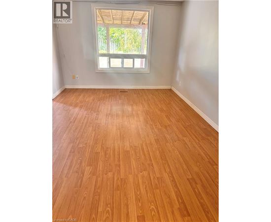 A room with wooden flooring and a window.