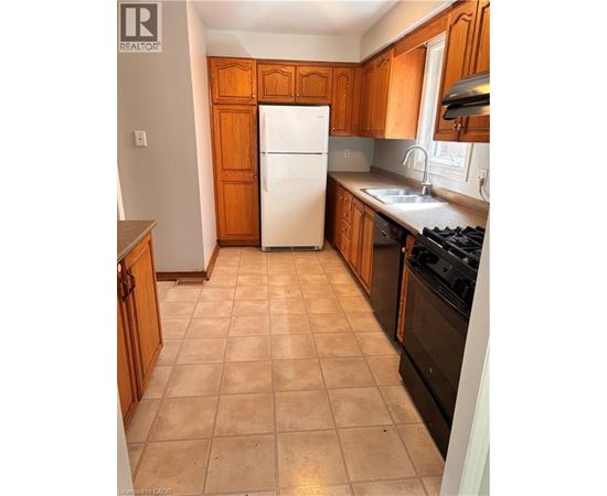 A kitchen with wooden cabinets and a white fridge.