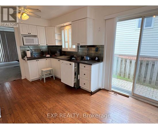 A kitchen with white cabinets and a black countertop.